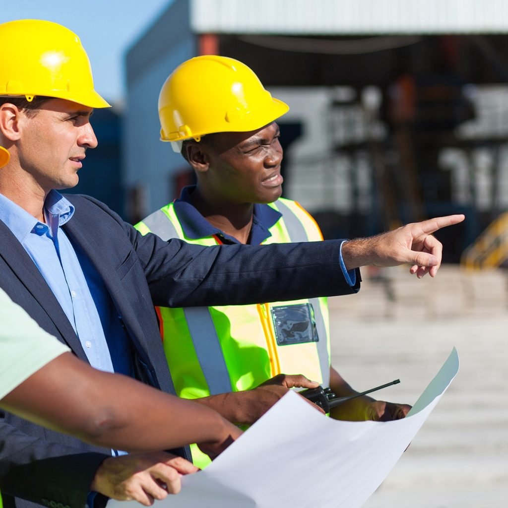 group of architect and construction workers on site with blue print